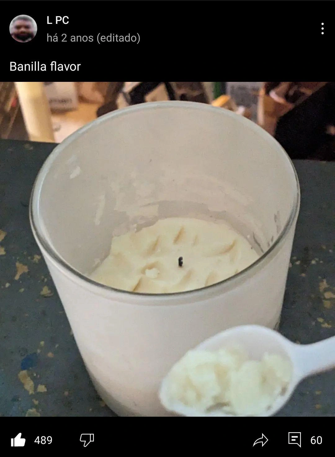 Screencap of a social media post where the user has a spoonful of candle wax in the foreground and a candle with chunks taken out of it in the background. User says "Banilla flavor".