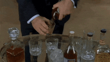 Jack Donaghy pouring himself a glass of whiskey.