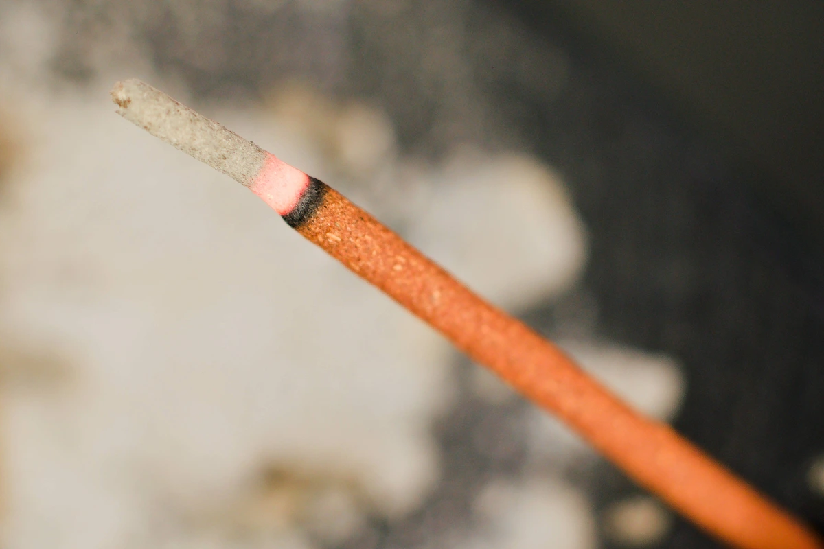 An extreme close up macro shot of a burning stick of Japanese incense.