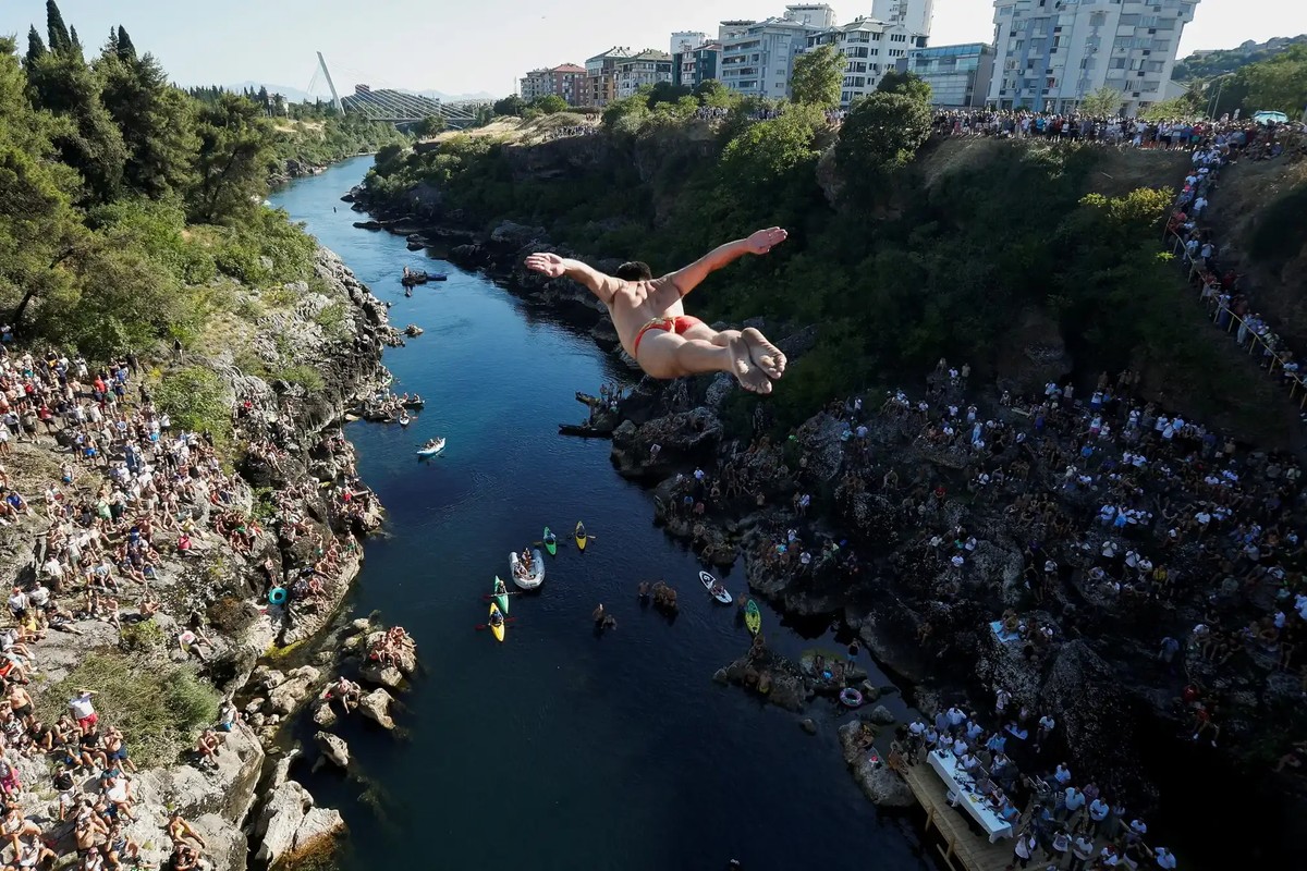 Evald Krnic makes a swallow-style jump, from the 23 metre-high Vizier bridge over the Morača River.